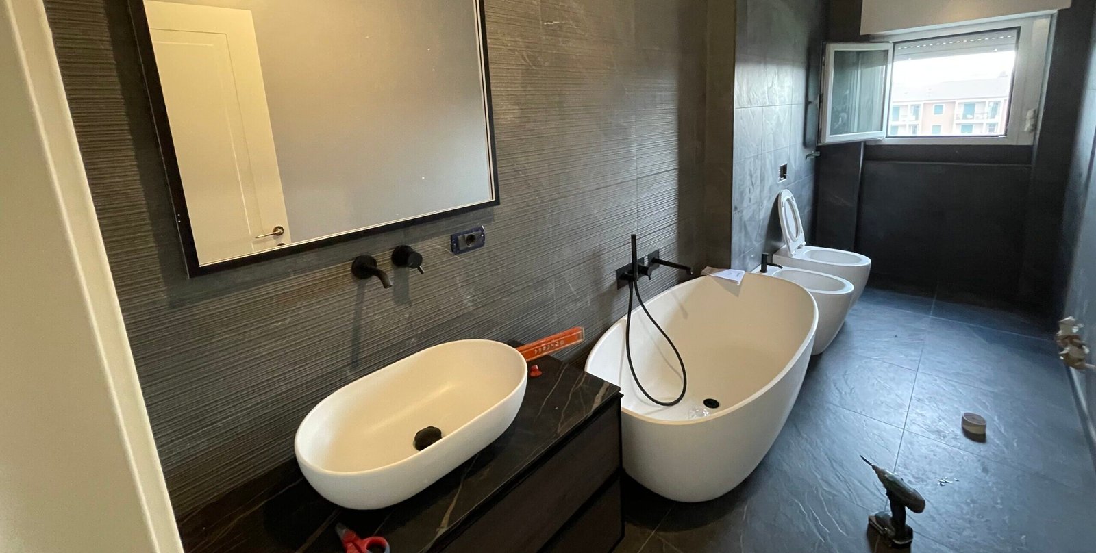 Installazione dei nuovi impianti e posa dei rivestimenti nella ristrutturazione bagno.